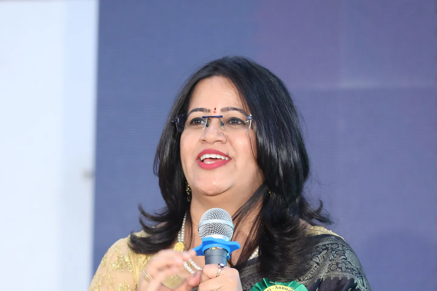 Shruti speaking with a microphone at an event